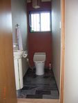 トイレです。　これもお客様の奥様のデザインです。正面のワンポイントの壁が遊び心があっていいですね。床は黒とグレーのマーブル模様の大理石です。